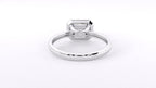 A silver-toned ring with a rectangular emerald-cut clear gemstone in a four-prong setting, shown on a plain white background.