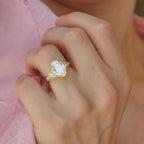 Lifestyle hand shot of a luxury 4 carat oval lab-grown diamond engagement ring with side accent stones.