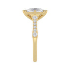 Close-up side view of the pave accent stones along the band of a yellow gold cushion diamond ring.