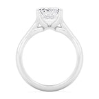 Close-up side profile view highlighting the gallery basket and prongs of a white gold emerald diamond ring.