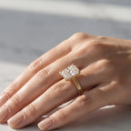 5 CT radiant cut lab-grown diamond engagement ring on finger in hand-engraved yellow gold setting under natural light.
