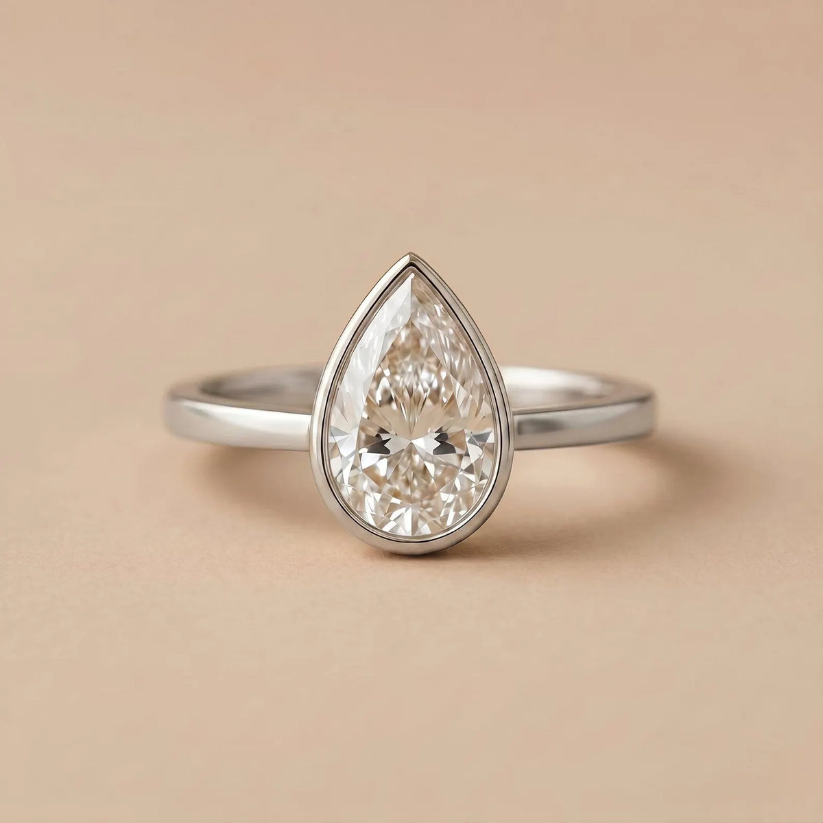 Front view of a 3 CT pear-shaped lab-grown diamond ring in a modern white gold full bezel setting.