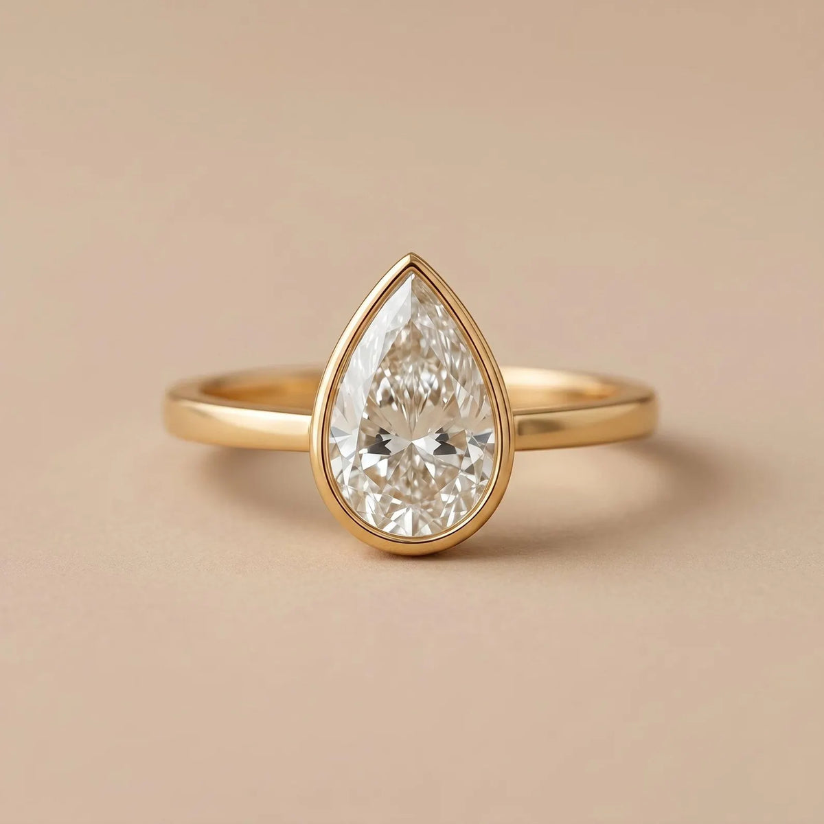 Front view of a 3 CT teardrop pear cut lab diamond engagement ring in a yellow gold bezel setting.