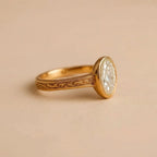 Side angle view of a 2 CT oval lab-grown diamond ring in a yellow gold milgrain bezel with engraved scrollwork band.