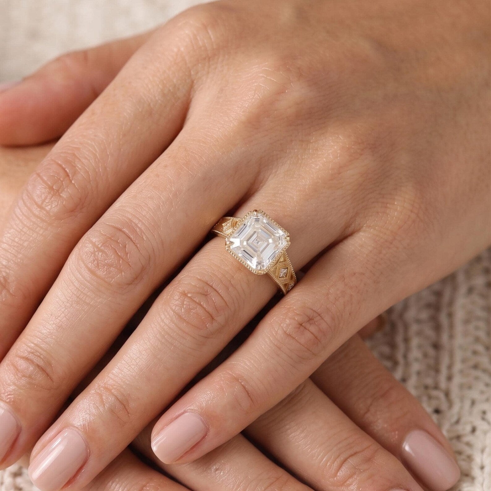 Model wearing a 3 CT Asscher-cut lab-grown diamond engagement ring with a milgrain bezel setting and vintage geometric gold band.