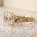 Side view of a 3 carat Asscher cut lab diamond ring highlighting the hand-engraved chevron pattern band set with bezel round accent diamonds.