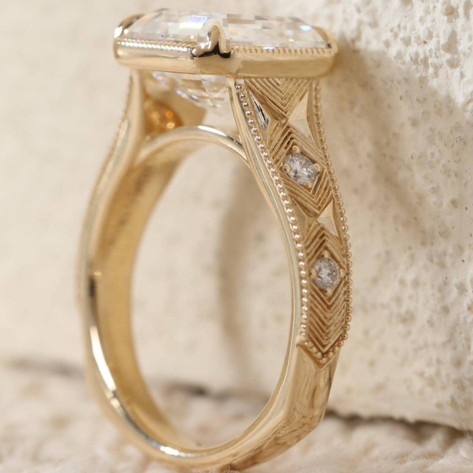 Profile view of a vintage-inspired 3 CT Asscher lab diamond engagement ring showing gold milgrain border and detailed filigree shank.