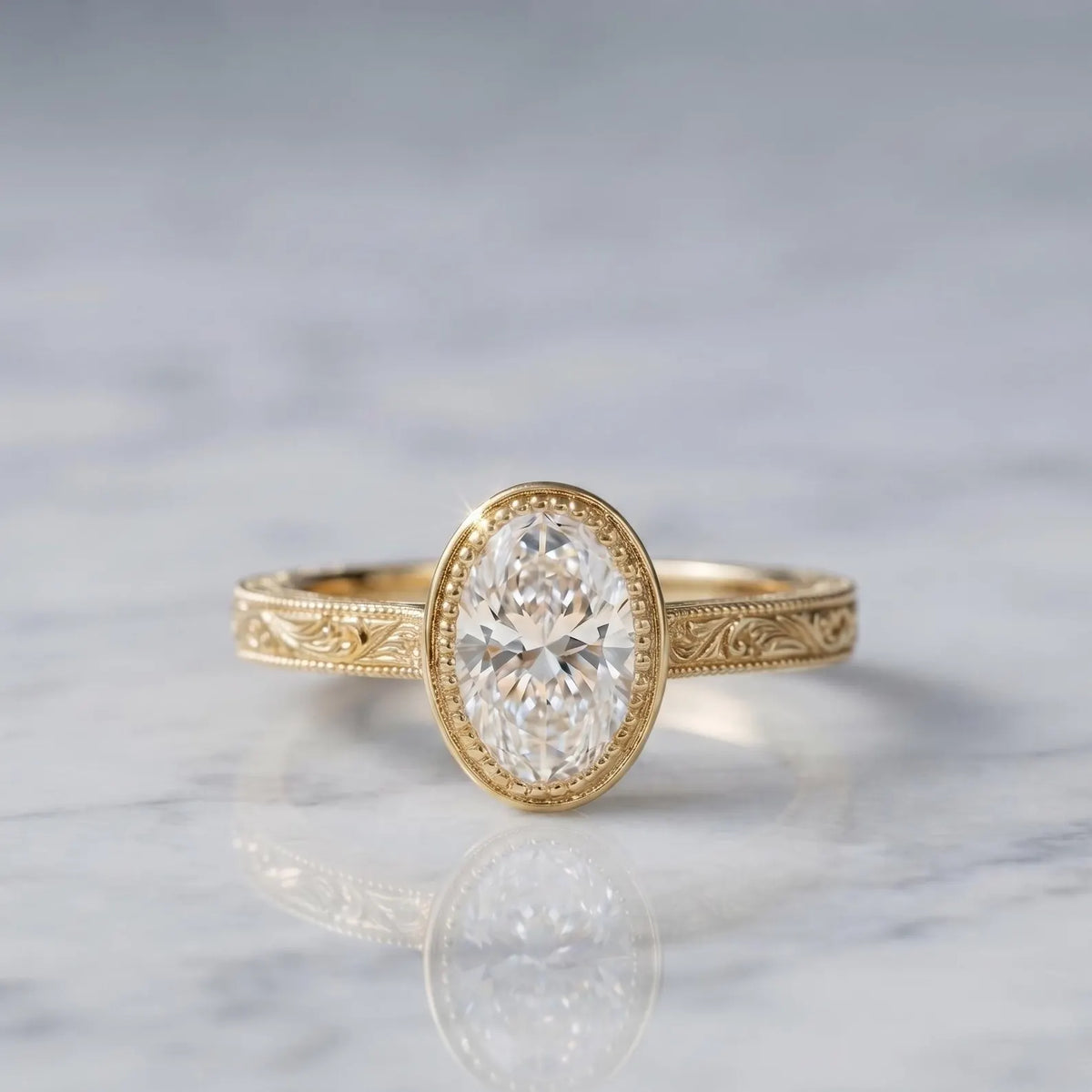 3 CT oval lab-grown diamond engagement ring in yellow gold milgrain bezel with hand-engraved scrollwork sitting on marble.