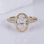 Front top view of a 3 CT oval lab-grown diamond ring with thin bezel frame, corner prongs, and diamond pavé shank.