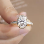 Close-up front view of a 3 CT oval lab-grown diamond ring held in hand showcasing stone brilliance and yellow gold setting.