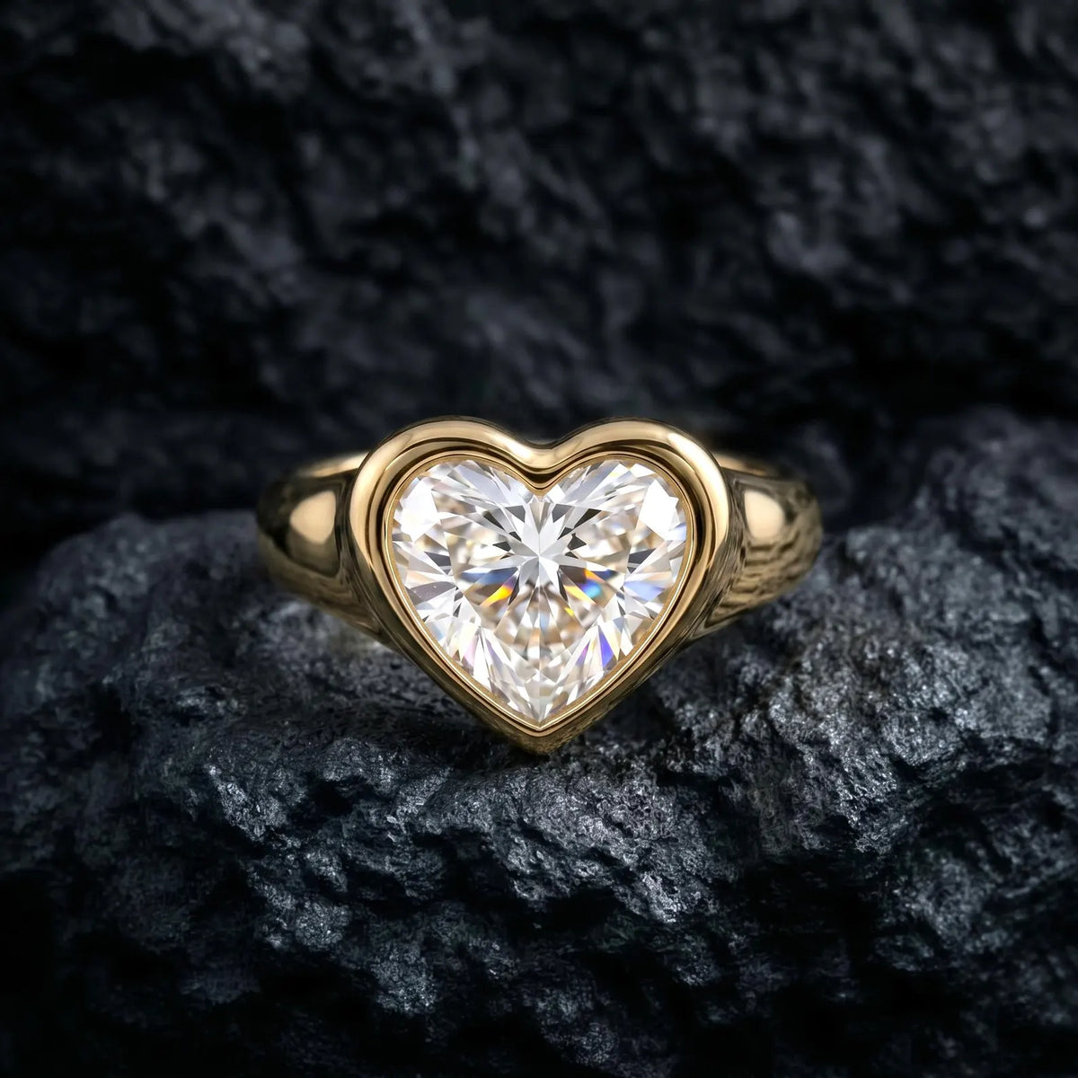 Front view of a 3 carat heart cut lab diamond enclosed in a thick, polished yellow gold bezel ring.