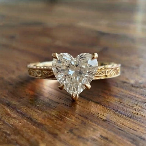 Front view of a 2 CT heart-shaped lab-grown diamond engagement ring with hand-engraved vintage scrollwork on a yellow gold band.
