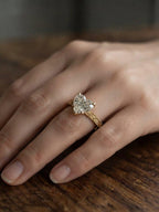 Person wearing a 2 CT heart lab-grown diamond engagement ring featuring an intricate vintage hand-carved yellow gold band.