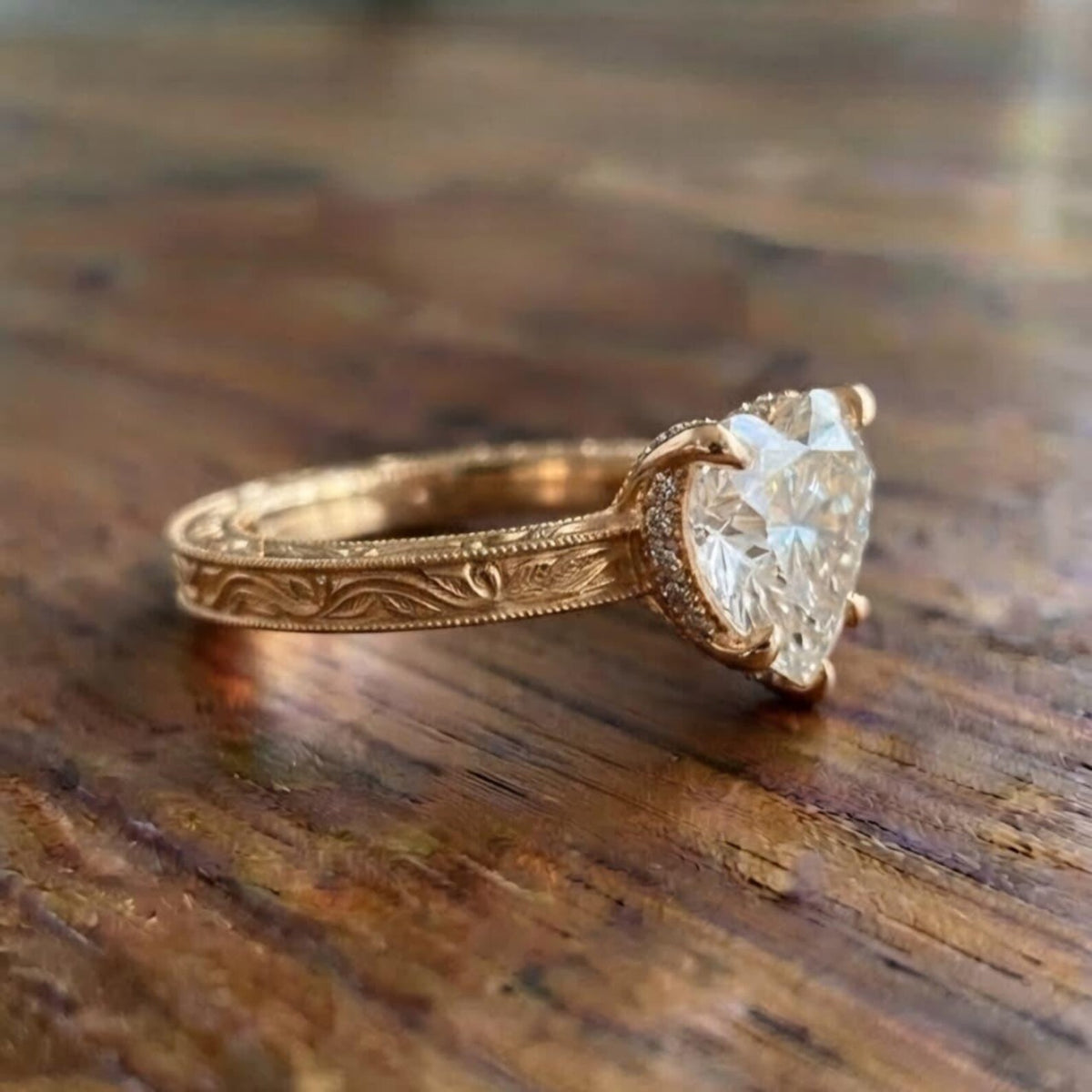 Detailed side view of yellow gold vintage heart diamond ring showcasing hand-carved floral motifs and hidden halo details.