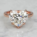 Front top view of a 3 carat heart cut lab-grown diamond solitaire ring set in 14K rose gold prongs.