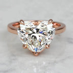 Front top view of a 3 carat heart cut lab-grown diamond solitaire ring set in 14K rose gold prongs.