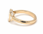 Side angle view of 4 CT emerald cut lab diamond three-stone engagement ring in yellow gold bezel setting.