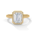 Top front view of a 4 CT emerald cut lab-grown diamond engagement ring with pave frame halo on a plain yellow gold band.