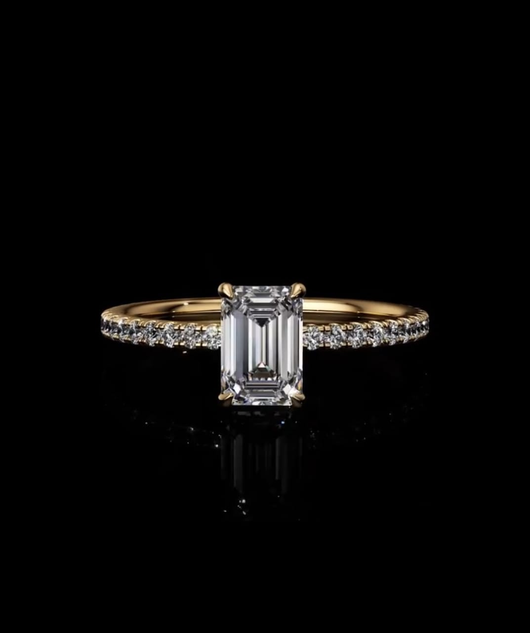 Front view of an IGI certified 2 carat emerald cut lab diamond engagement ring set on a delicate yellow gold micro-pave band.