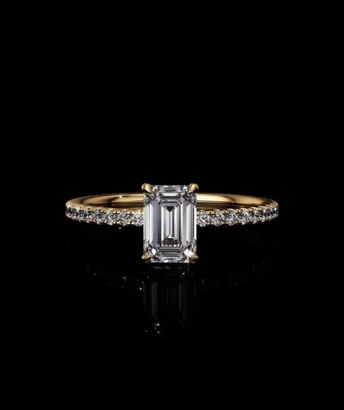 Front view of an IGI certified 2 carat emerald cut lab diamond engagement ring set on a delicate yellow gold micro-pave band.