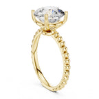Gold ring with a large round cut diamond on a white background