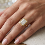 Close-up on hand showing a 3 CT radiant cut lab-grown diamond engagement ring in a yellow gold milgrain bezel setting.