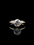 Direct view of a 2 CT round brilliant lab-grown diamond solitaire engagement ring set on a polished yellow gold plain band.