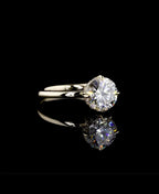 A classic solitaire engagement ring featuring a round brilliant-cut diamond set in a yellow gold band