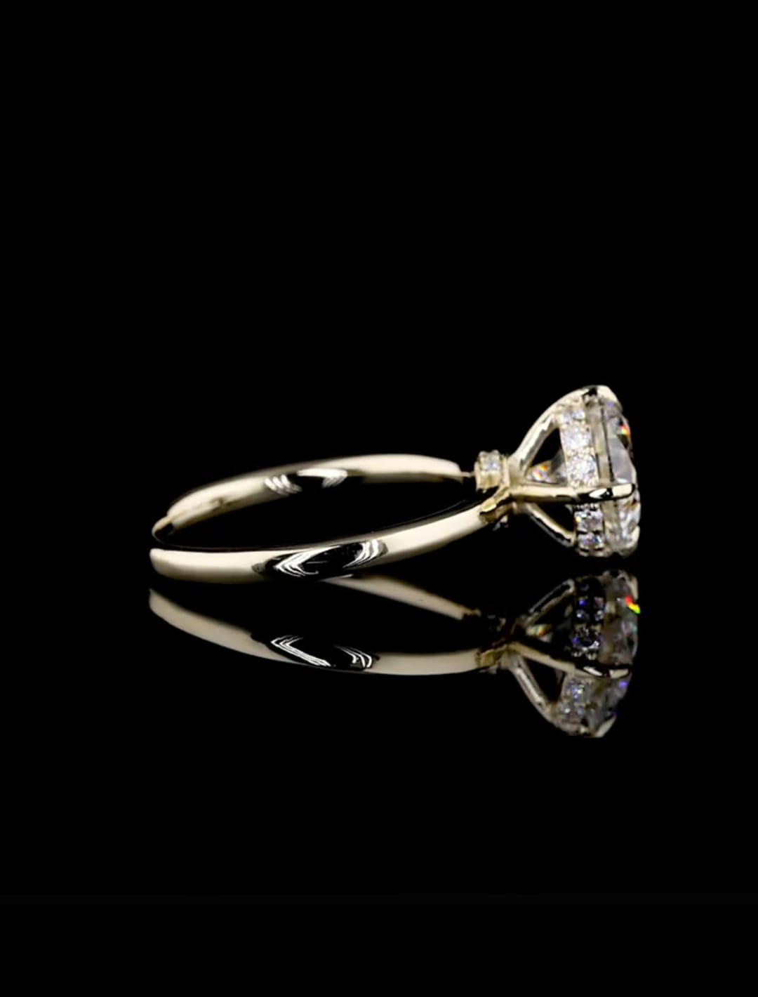 A yellow gold ring with a large clear gemstone in a triangular setting