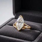 3 carat marquise cut lab diamond ring with a yellow gold split shank band displayed inside a plush gray velvet box.