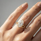 On-finger top view of a 3 CT marquise lab grown diamond ring set in yellow gold with protective V-tip bezel caps.