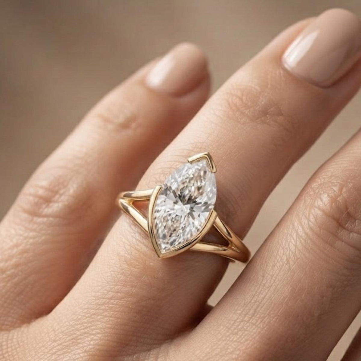 Angled lifestyle view of a 3 CT vertical marquise lab grown diamond solitaire ring on a hand in warm yellow gold.