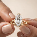 Detailed close-up view of a hand holding a 3 carat marquise lab diamond ring showcasing the airy open split shank design.