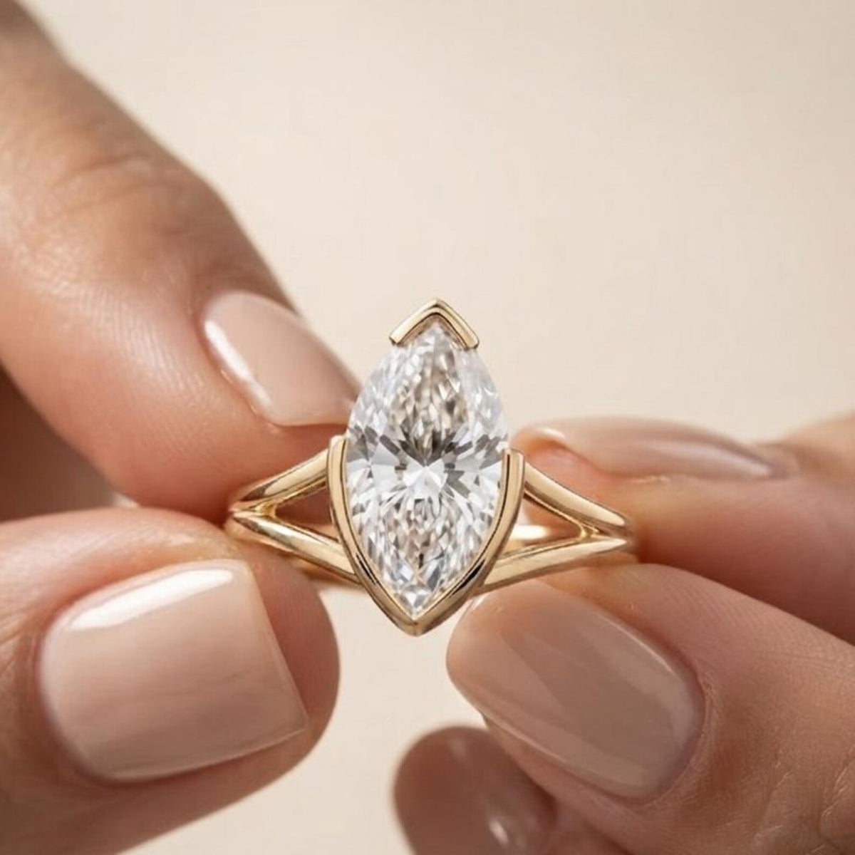 Detailed close-up view of a hand holding a 3 carat marquise lab diamond ring showcasing the airy open split shank design.