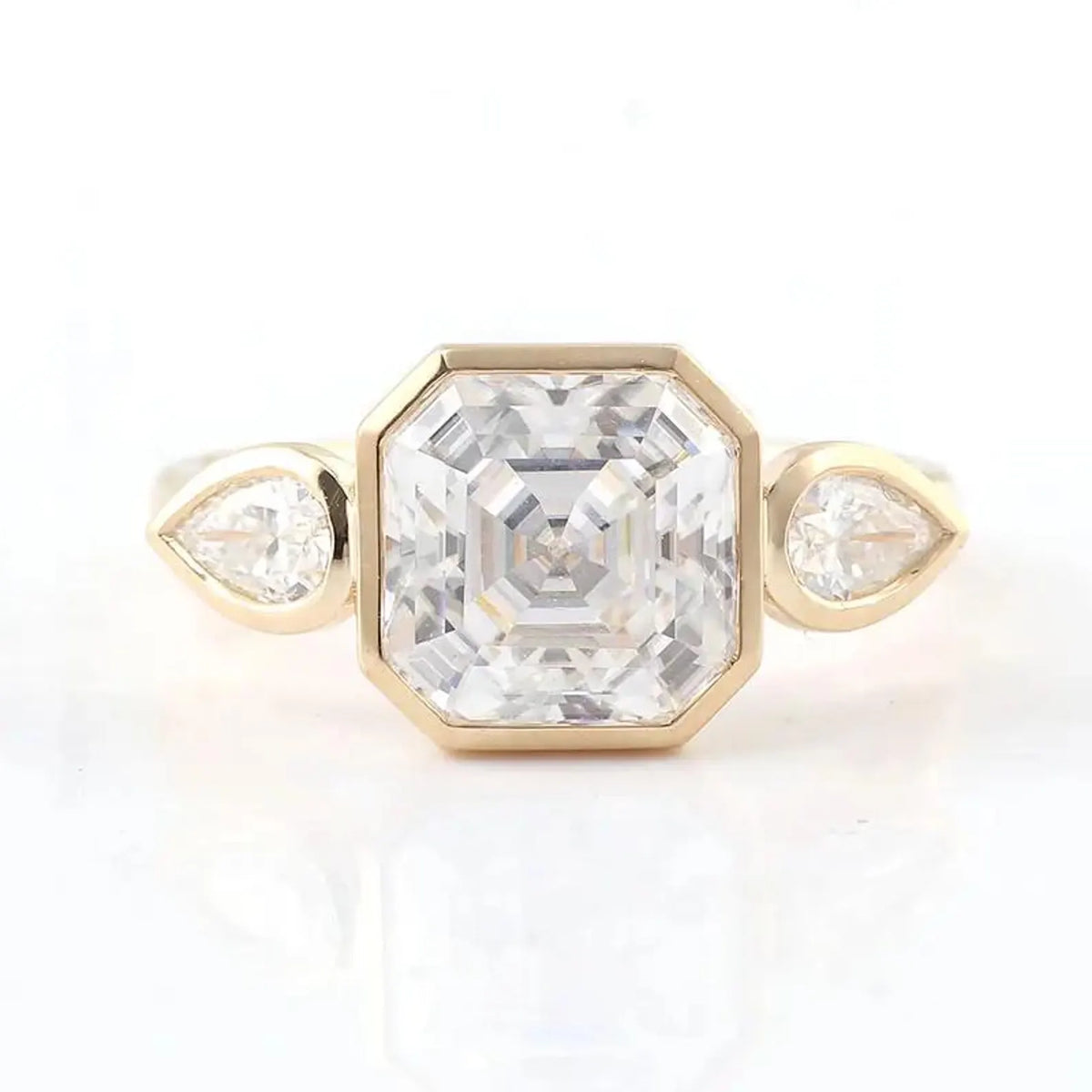 Top-down view of a full bezel 3 CT Asscher cut lab grown diamond ring flanked by two bezel pear side stones.