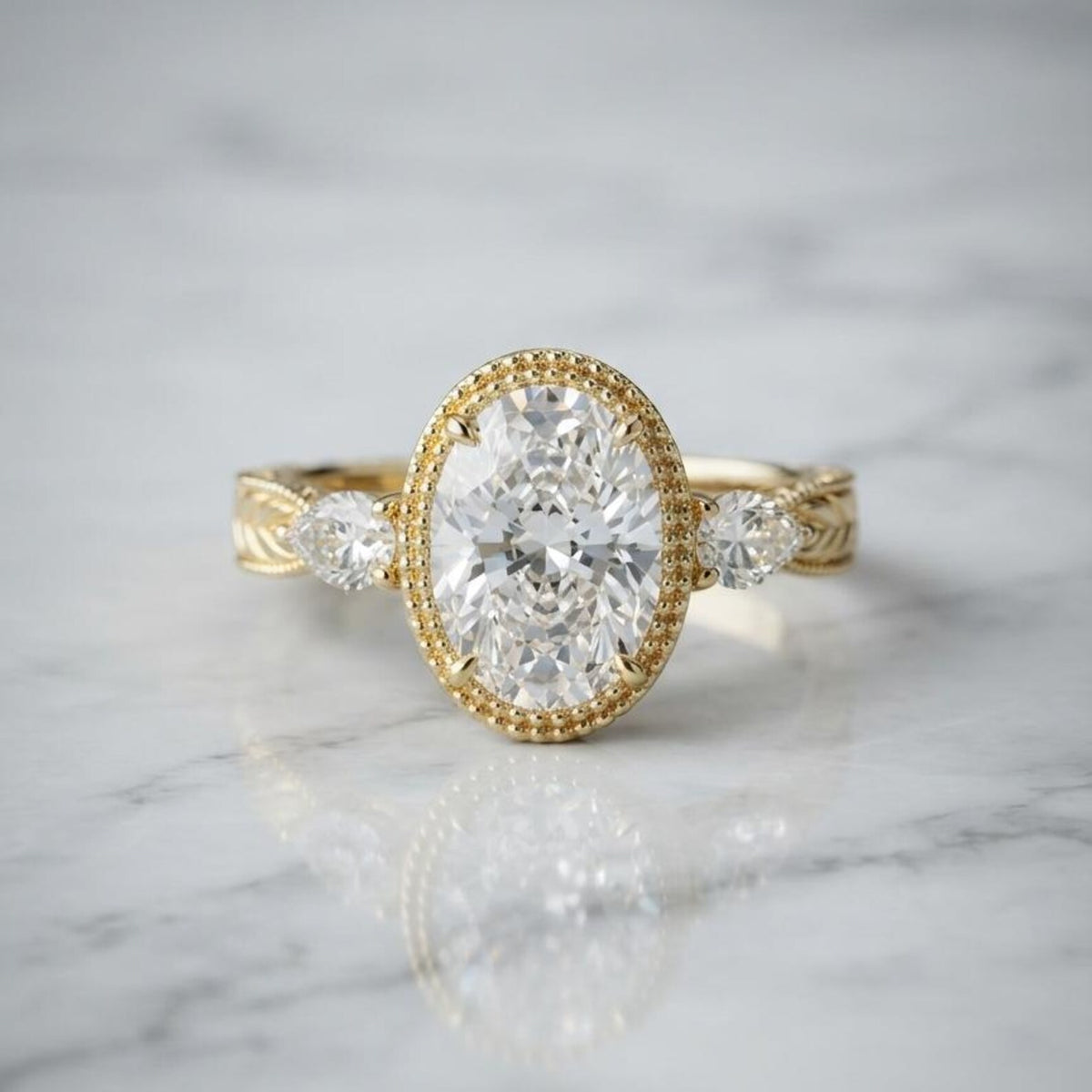 Front view of a 3 CT oval cut lab grown diamond engagement ring on white marble showing milgrain bezel setting and side pear diamonds.