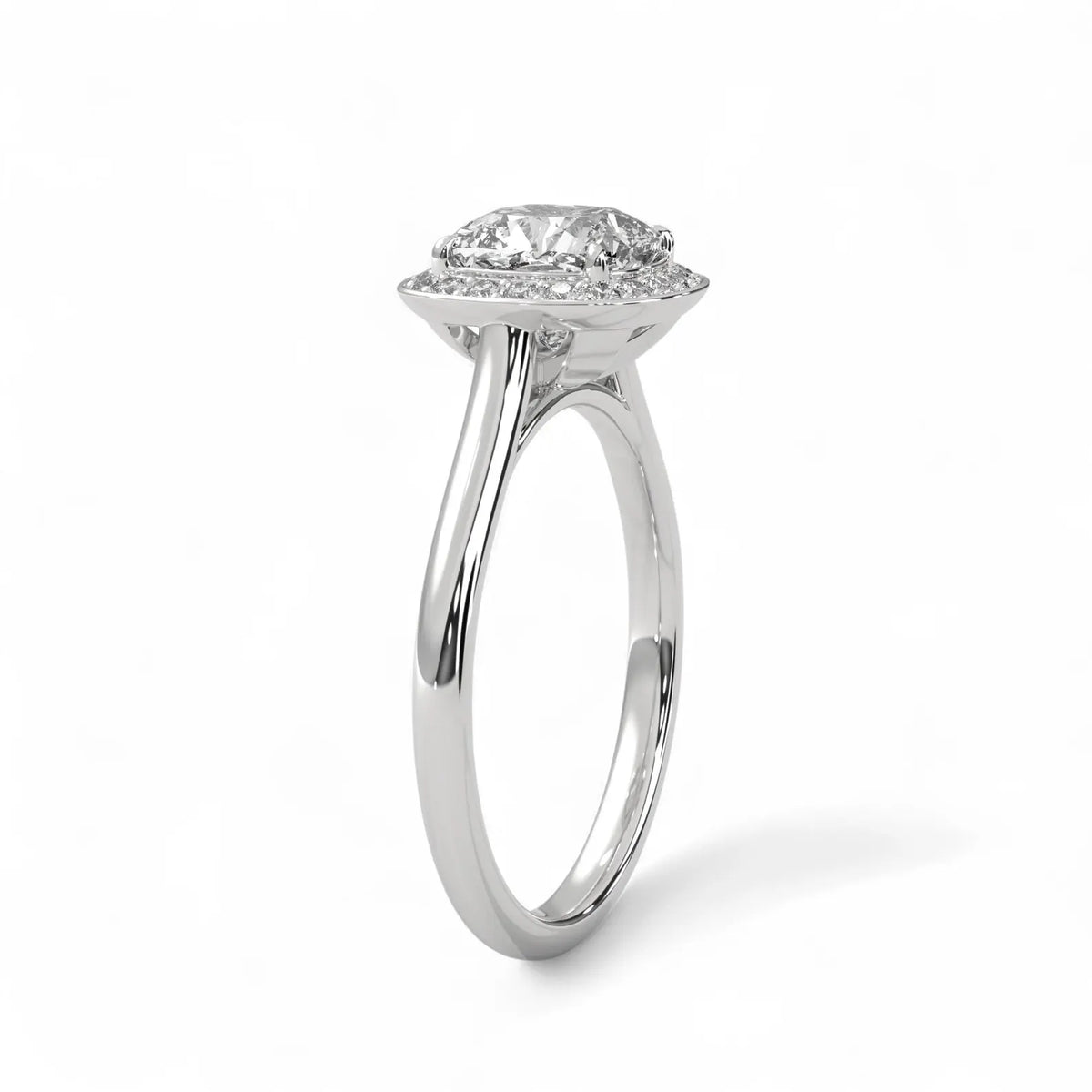 Angled side view of a white gold 3 CT cushion lab diamond halo engagement ring showing cathedral setting.