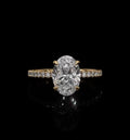 Top view of a 2 CT oval cut lab-grown diamond engagement ring set in four yellow gold prongs on a delicate micro-pavé band.