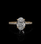 Top view of a 2 CT oval cut lab-grown diamond engagement ring set in four yellow gold prongs on a delicate micro-pavé band.