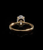 Under-gallery view of a yellow gold oval diamond engagement ring showcasing the interior setting collar and solid polished band base.