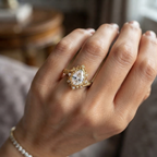 On-hand view of a 3 CT pear cut lab grown diamond vintage sunburst halo ring in yellow gold.