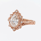 Angled side profile of a rose gold 3 CT pear cut lab diamond engagement ring with starburst halo and engraved shank.