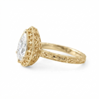 Side profile view of a yellow gold 3 CT pear cut lab diamond ring showing detailed scrollwork under-gallery filigree.