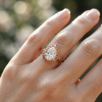 On-hand view of a rose gold 3 CT pear cut lab diamond engagement ring showcasing antique filigree detail and floral band.