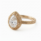 Angled perspective view of a yellow gold 3 CT pear cut lab grown diamond engagement ring with filigree bezel halo.