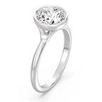Angled perspective view of a 3 carat round cut lab diamond bezel ring in white gold.