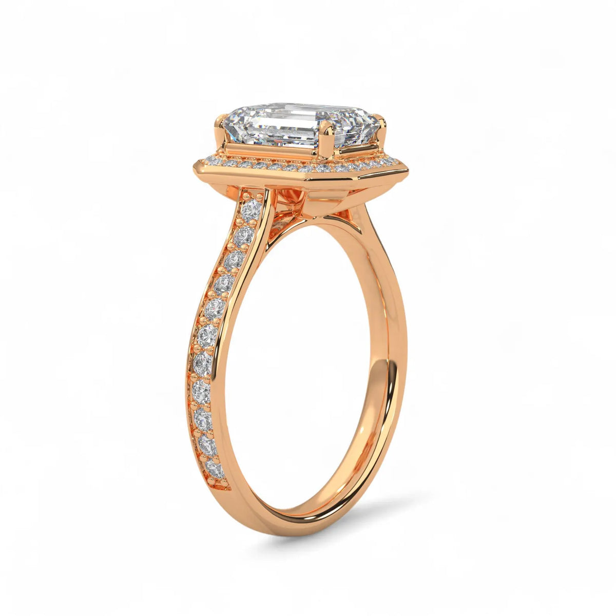 Side angle view of a 4 CT emerald cut lab grown diamond halo engagement ring in rose gold with pave band.