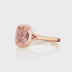 Angled top view of a 2 CT fancy pink cushion cut lab diamond ring in a sleek rose gold bezel setting.