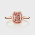 Direct top view of an elongated 2 carat fancy pink cushion cut lab grown diamond in a protective rose gold bezel setting.