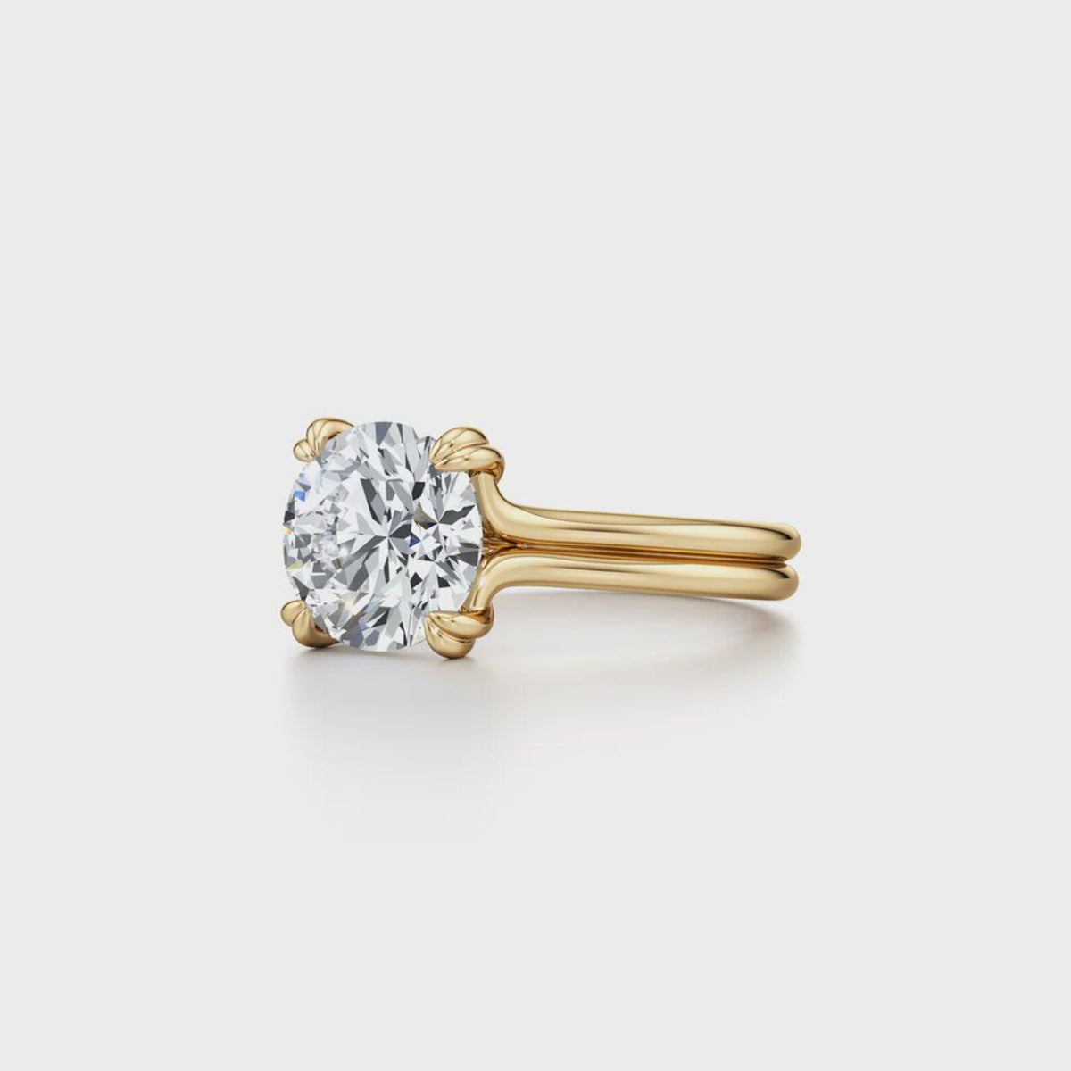 Angled side view of a 2 CT round cut lab grown diamond ring with a double wire yellow gold band.
